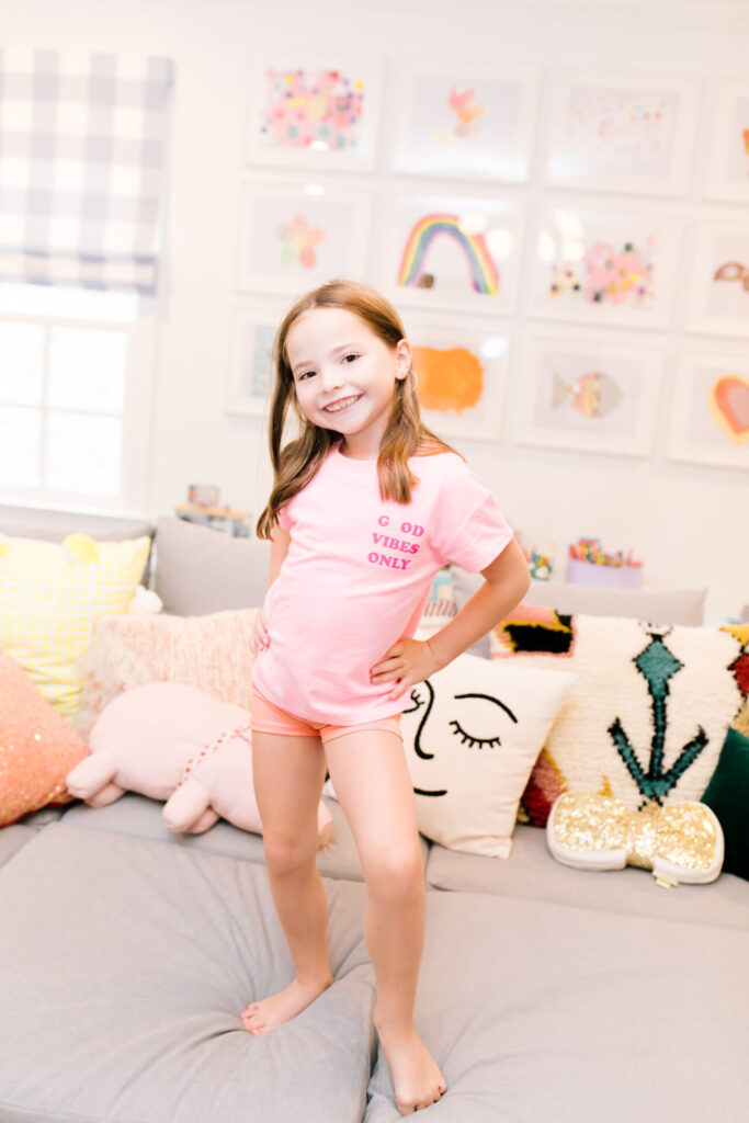 Tween Fashion by popular Nashville fashion blog, Hello Happiness: image of a girl standing on a grey couch and wearing Target gym shorts and a Target Good Vibes Only t-shirt. 