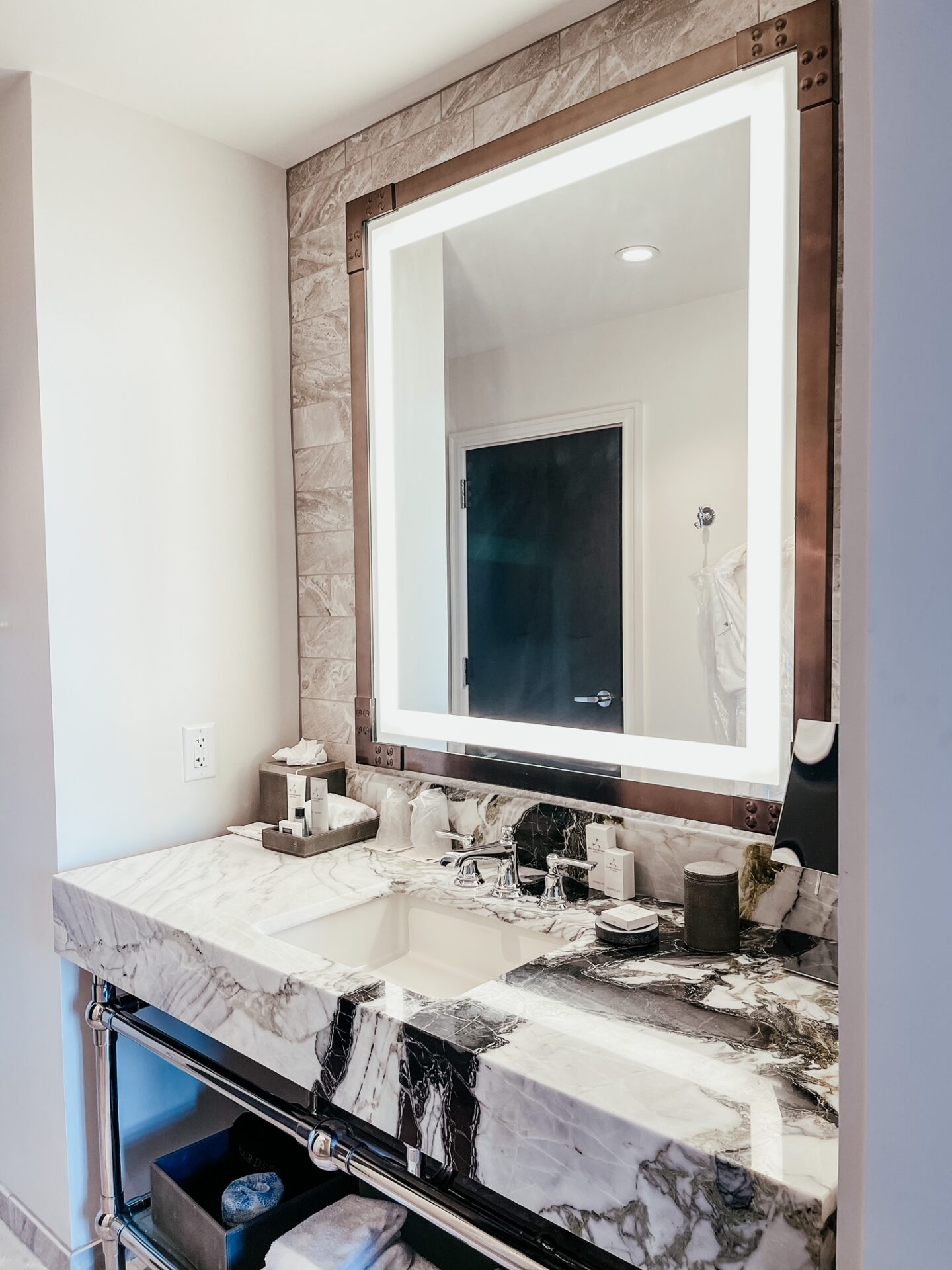Girls Getaway by popular Nashville travel blog, Hello Happiness: image of a hotel bathroom with a black and white marble counter top. 