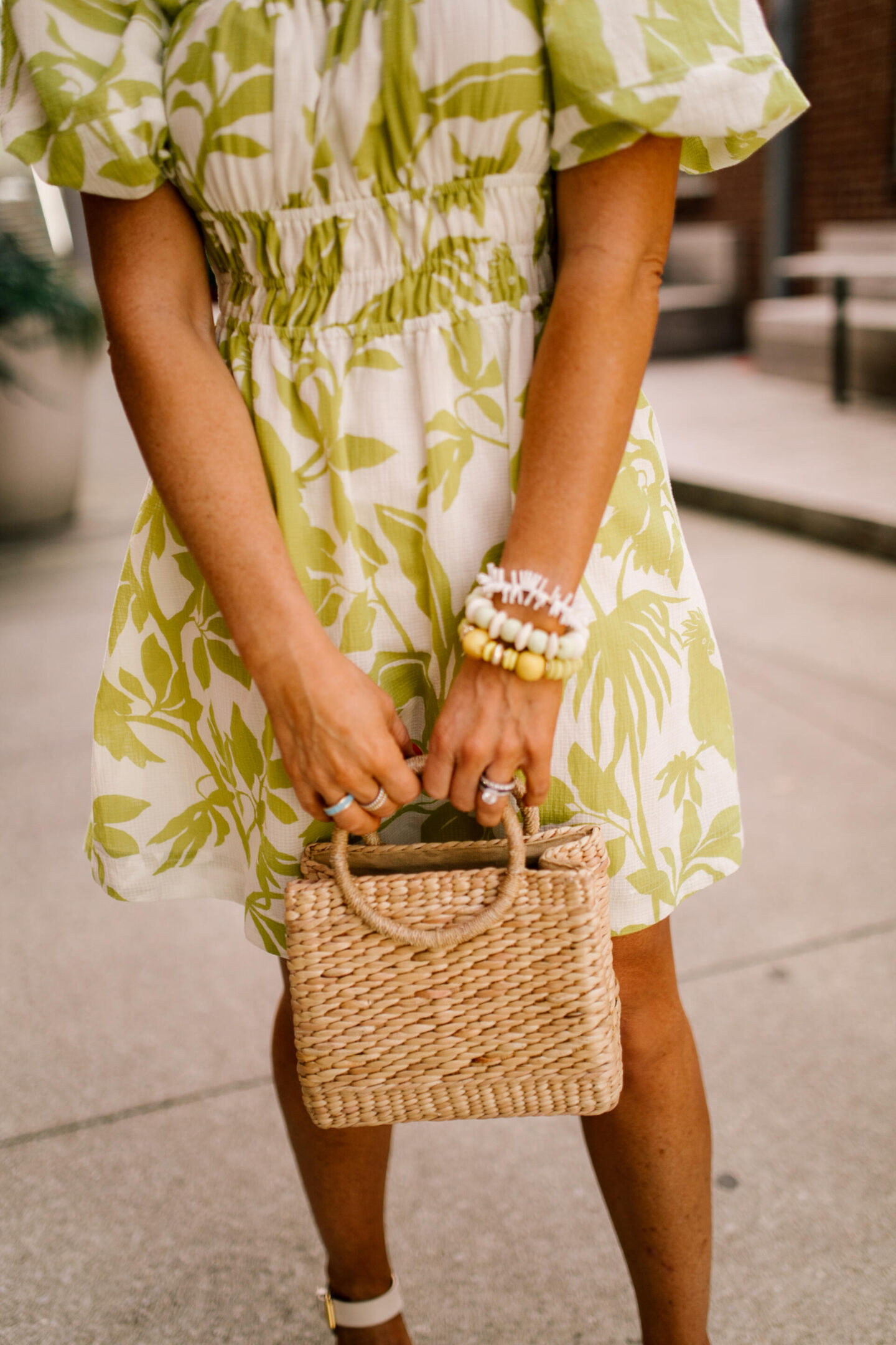 Woven Bag by popular Nashville fashion blog, Hello Happiness: image of a woman wearing a puff sleeve dress and holding a luna small bag. 