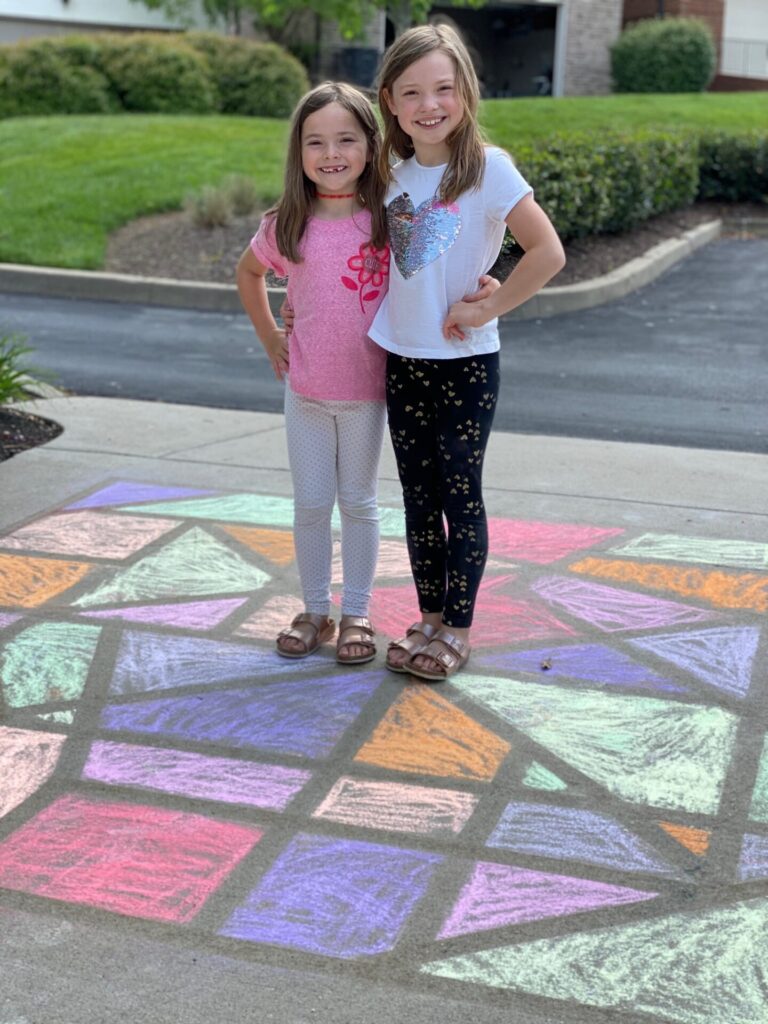 Year in Review by popular Nashville lifestyle blog, Hello Happiness: image of two young girls standing together on some chalk art. 