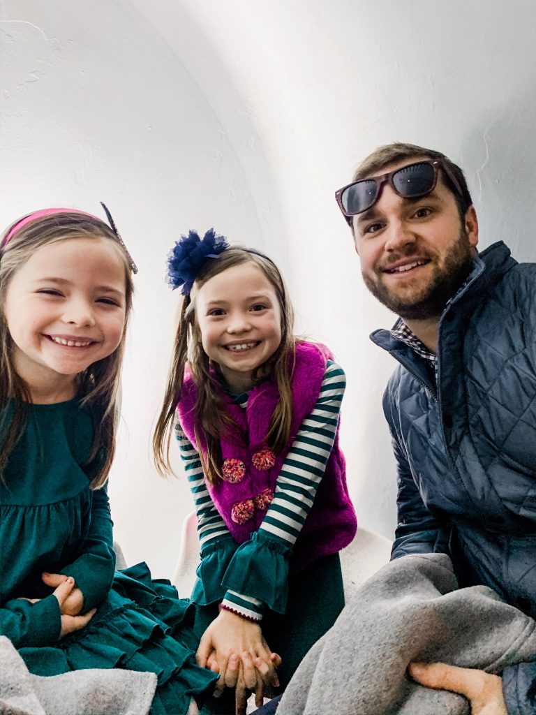 Meet Me for a Weekend in St. Louis | The Perfect Family Getaway by popular travel blog, Hello Happiness: image of a dad sitting with her girls at Union Station. 