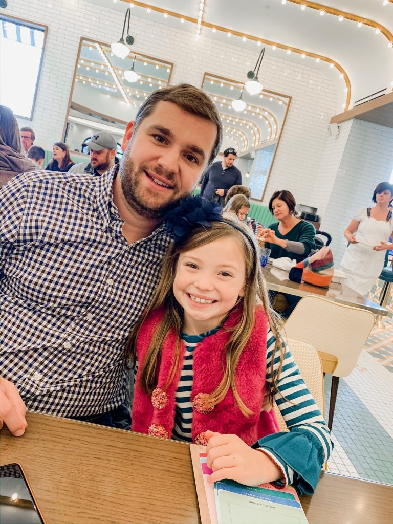 Meet Me for a Weekend in St. Louis | The Perfect Family Getaway by popular travel blog, Hello Happiness: image of dad and his daughter sitting at the Soda Fountain. 