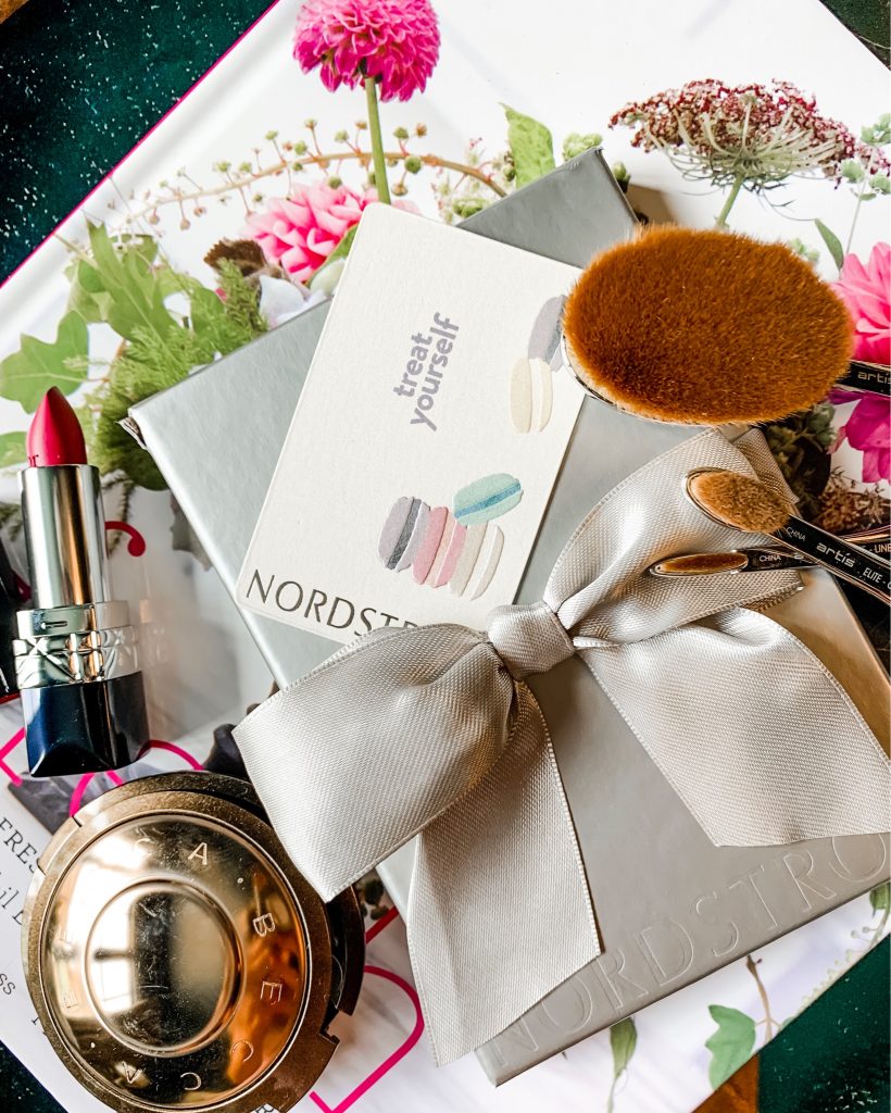 Making My List...How to Shop the 2019 Nordstrom Anniversary Sale by popular Nashville fashion blog, Hello Happiness: flat lay image of a Nordstrom gift box, Artis makeup brushes, Abecca compact, pink lipstick and Nordstrom catalogue.