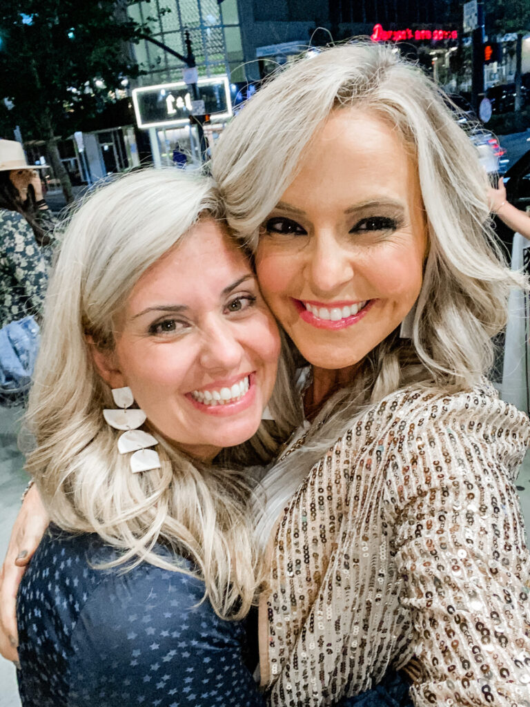 Staycation Ideas by popular Nashville travel blog, Hello Happiness: image of two women standing together outside in Nashville, TN and taking a selfie. 