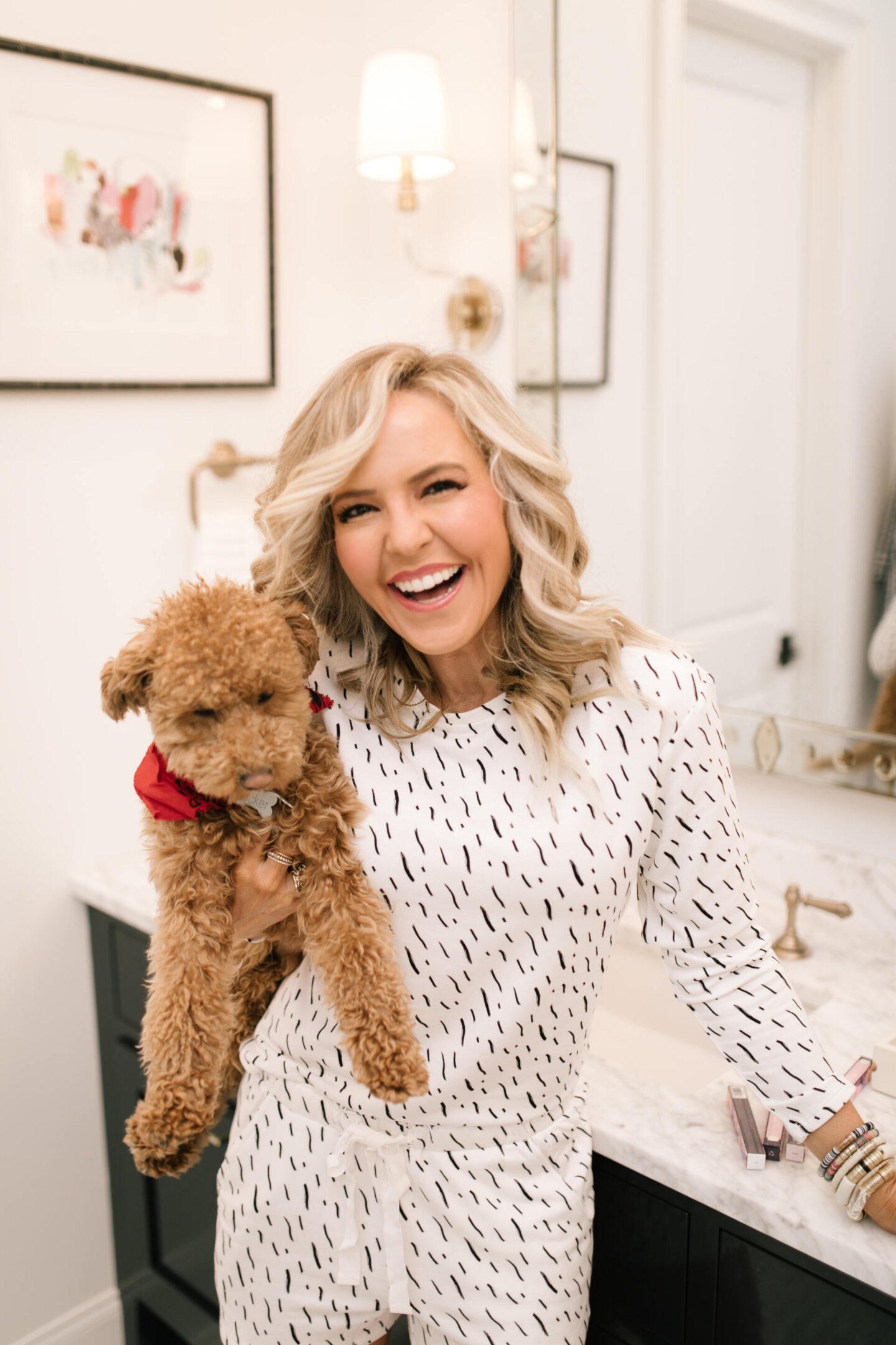 Dog Shops by popular Nashville lifestyle blog, Hello Happiness: image of a woman wearing a brushstroke pajama top and brushstroke pajamas shorts while holding her teacup goldendoodle. 