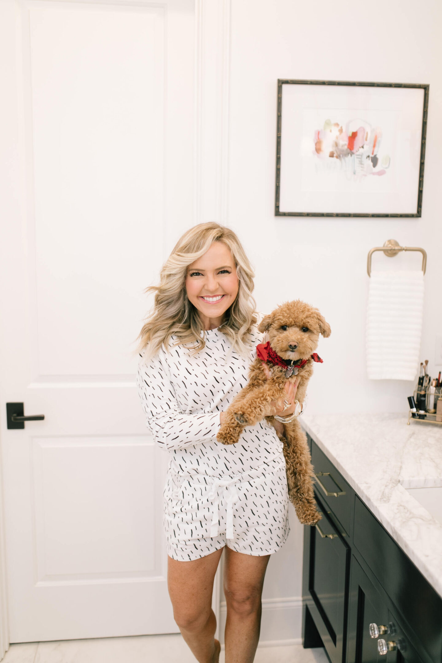 Dog Shops by popular Nashville lifestyle blog, Hello Happiness: image of a woman wearing a brushstroke pajama top and brushstroke pajamas shorts while holding her teacup goldendoodle. 