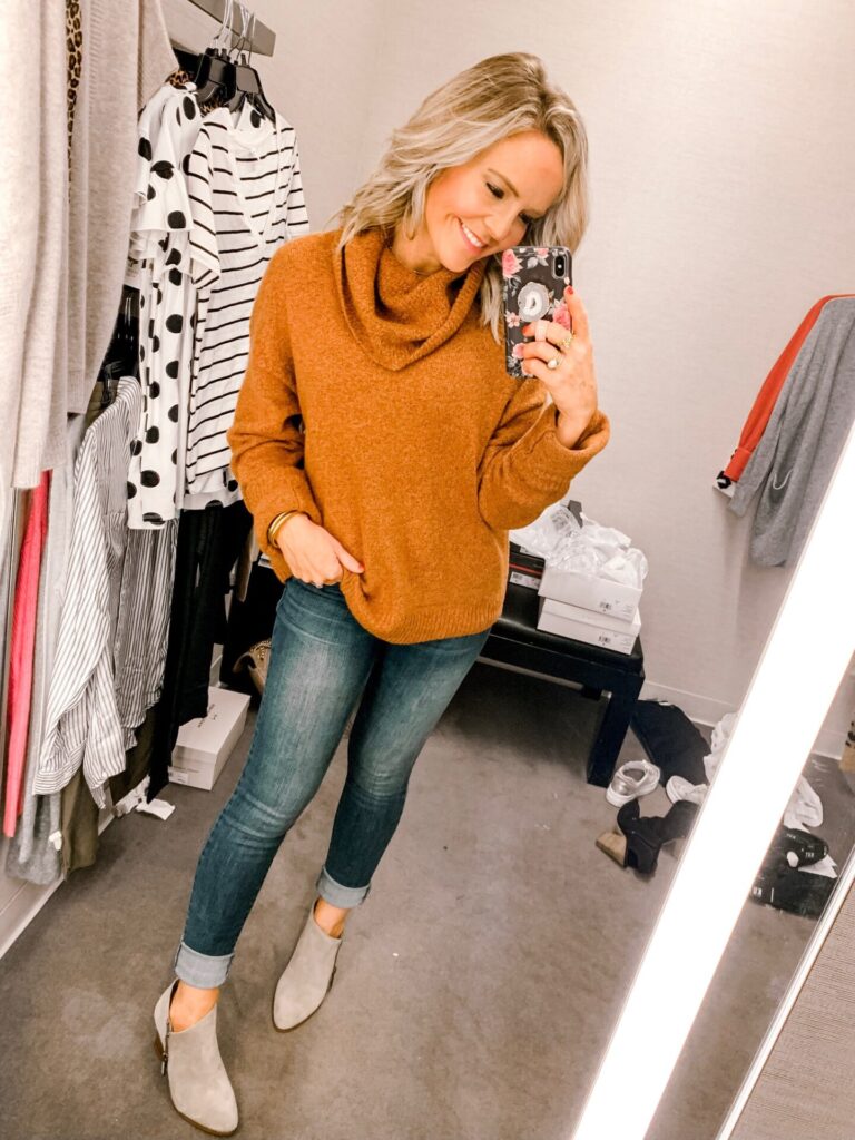 Nordstrom Anniversary Sale by popular Nashville fashion blog, Hello Happiness: image of a woman standing in a Nordstrom dressing room and wearing a Caslon turtleneck sweater, jeans, and ankle booties.  