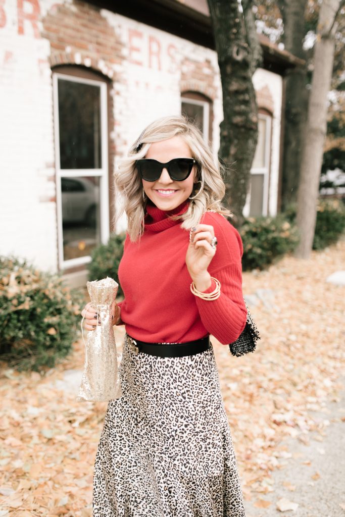 Cheers to Chicos RED by popular Nashville fashion blog, Hello Happiness: image of a woman outside wearing a Chicos red CASHMERE TURTLENECK, Chicos LEOPARD-PRINT MAXI SKIRT, Chicos SIMULATED STONE RING, and carrying a Chicos CONVERTIBLE TWEED SHOULDER BAG.