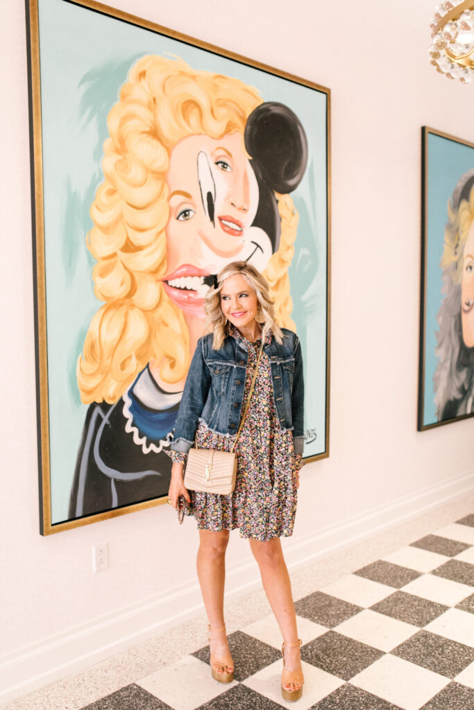 Personal Questions by popular Nashville lifestyle blog, Hello Happiness: image of Natasha Stoneking floral dress and jean jacket and standing my some framed modern art. 