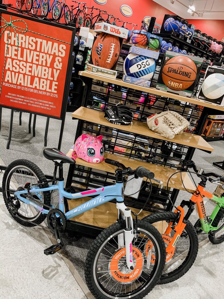 Unwrap the Magic of Sports with Dick's Gift Ideas by popular Nashville life and style blog, Hello Happiness: image of a Dick's Schwinn Signature Girls' SunnySide 20'' Bike, Nishiki Boys' Pueblo 24'' Mountain Bike, Portable Basketball Hoop, Rawlings Mitt, DSG Kids Glove and Ball, Soccer Ball, Volleyball, Wilson NFL 100 Football, Spalding Basketball.