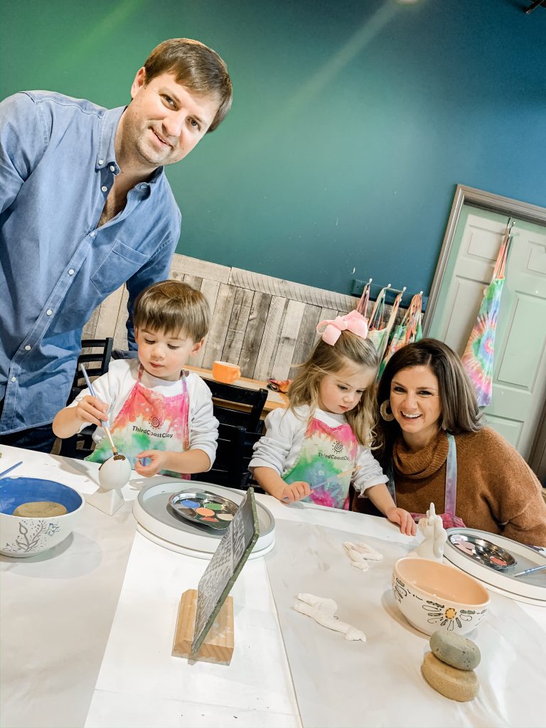 All Our Favorite Family Holiday Traditions by popular life and style blog, Hello Happiness: image of a family painting ceramincs. 