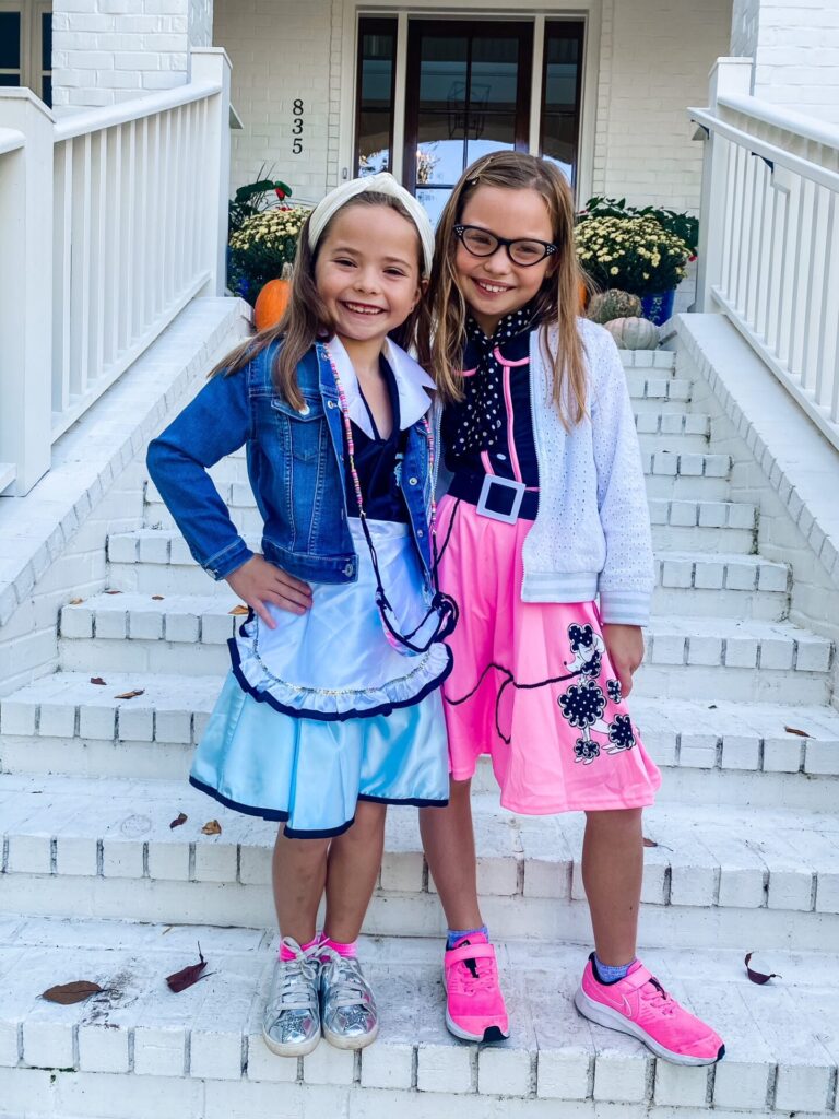 Year in Review by popular Nashville lifestyle blog, Hello Happiness: image of two young girls standing on the front steps to their house and wearing their Halloween costumes. 