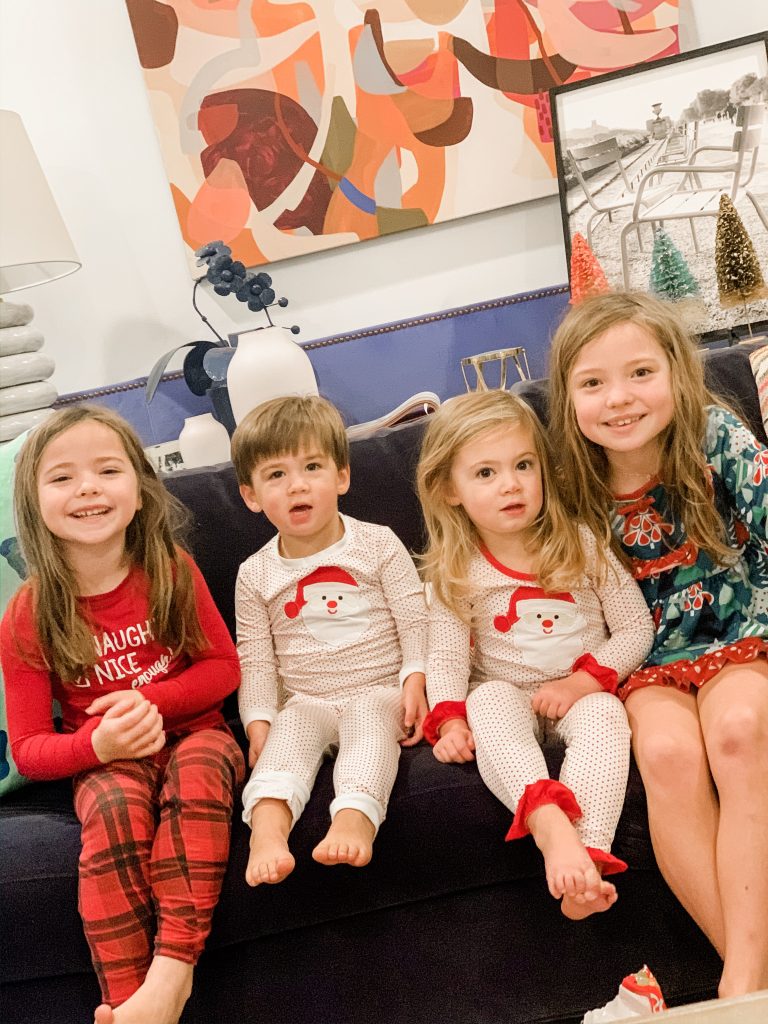All Our Favorite Family Holiday Traditions by popular life and style blog, Hello Happiness: image of four young kids sitting together on a couch. 