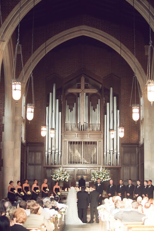 10 Year Wedding Anniversary by popular Nashville lifestyle blog, Hello Happiness: image of a bride and groom getting married in a cathedral filled with people and a wedding party wearing all black and standing up front. 