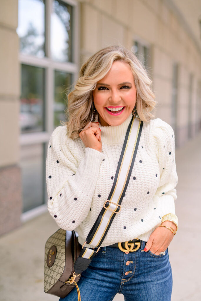 Accessory Concierge by popular Nashville fashion blog, Hello Happiness: image of Natasha Stoneking wearing a polka dot sweater and using a Accessory Concierge black, white, and gold purse strap. 