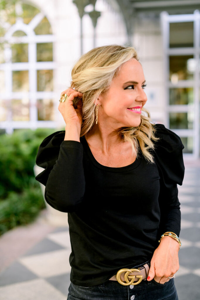 Accessory Concierge by popular Nashville fashion blog, Hello Happiness: image of Natasha Stoneking wearing a black puff sleeve top, Accessory Concierge infinity link drop earrings. 