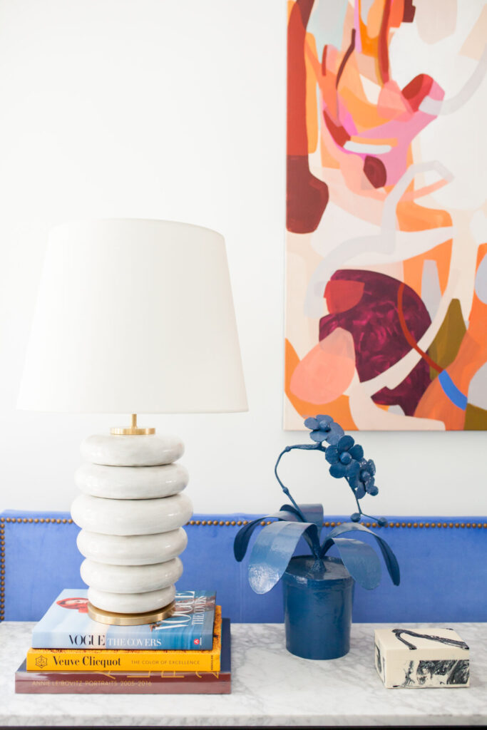Coffee Table Books by popular Nashville lifestyle blog, Hello Happiness: image of a white lamp on top of a stack of coffee table books that next to a blue orchid plant. 