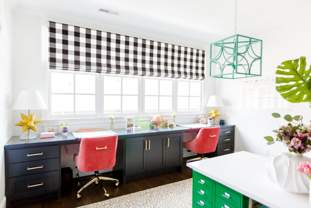 What COVID-19 Has Taught Me by popular Nashville lifestyle blog, Hello Happiness: image of a homeschooling room with black and white buffalo plaid roman shade, black desks, pink velvet desk chairs, gold star lamps, pink globe, green island counter and a leopard print rug. 