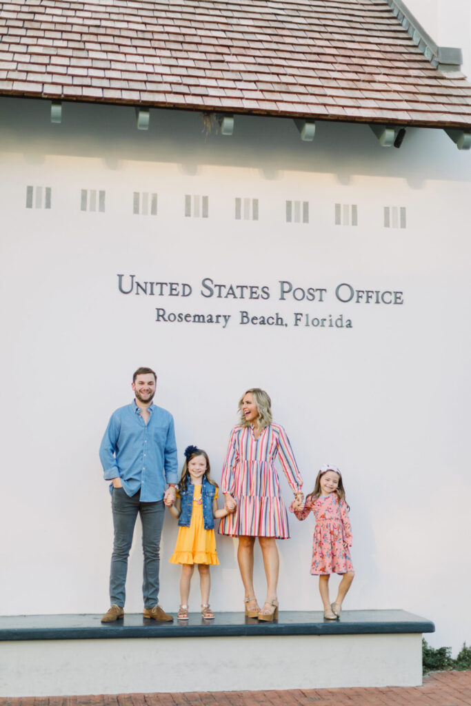 Father's Day Gift Guide by popular Nashville life and style blog, Hello Happiness: image of a mom, dad and their two daughters standing in front of the United States Post Office in Rosemary Beach, Florida. 