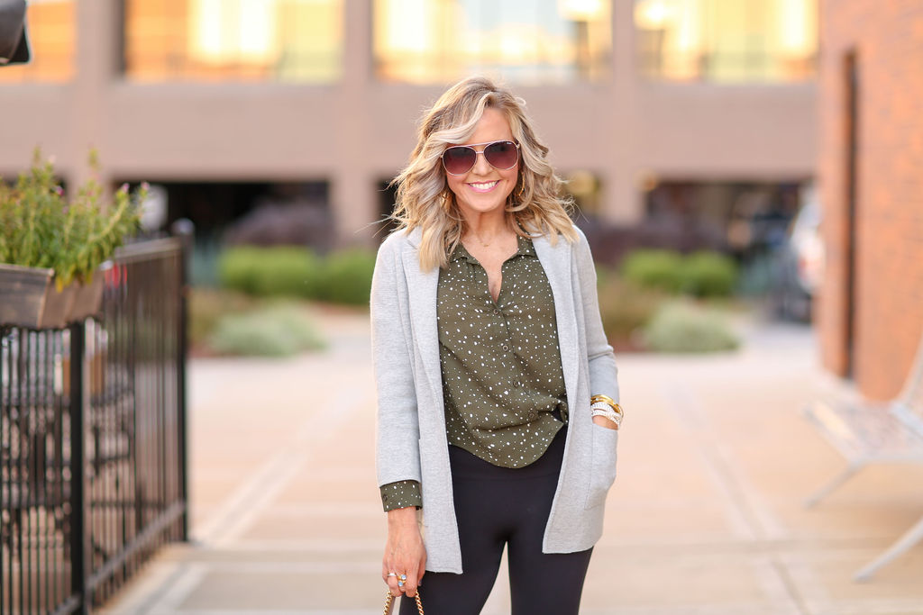 2019 Holiday Gift Guide | 2019 Holiday Gift Guide | Best Cyber Week Sales and Deals by popular Nashville life and style blog, Hello Happiness: image of a woman standing outside wearing a grey cardigan, green and white dot blouse, and black pants.