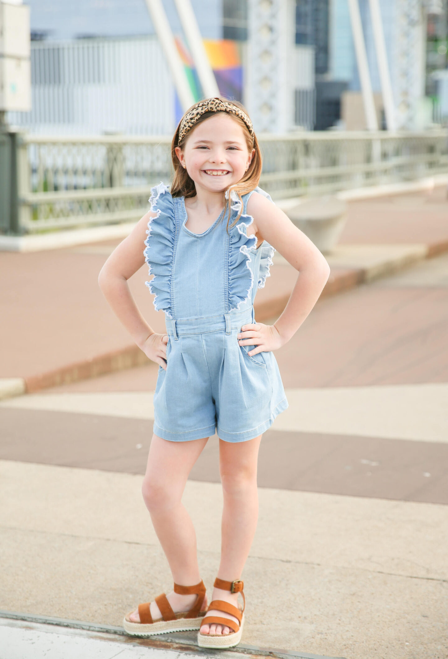 Summer Bucket List by popular Nashville lifestyle blog, Hello Happiness: image of a young girl wearing a chambray romper, leopard print knot headband and brown sandals. 