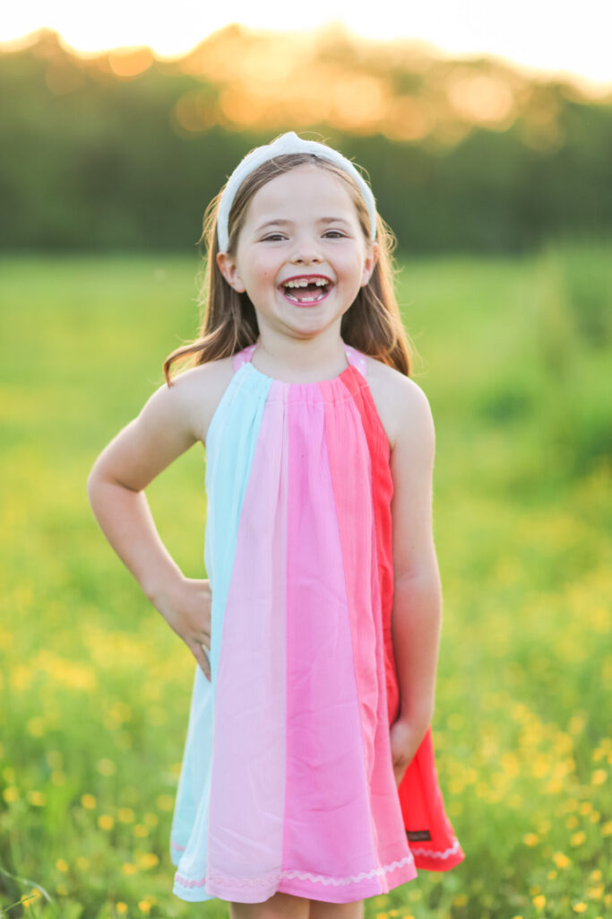 Summer Bucket List by popular Nashville lifestyle blog, Hello Happiness: image of a girl standing in a grassy meadow and wearing Matilda Jane Clothing dresses. 