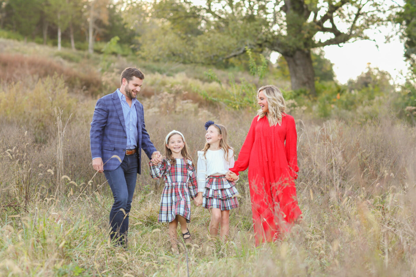 10 Year Wedding Anniversary by popular Nashville lifestyle blog, Hello Happiness: image of a mom and dad and their two daughters holding hand and walking together in a field. 