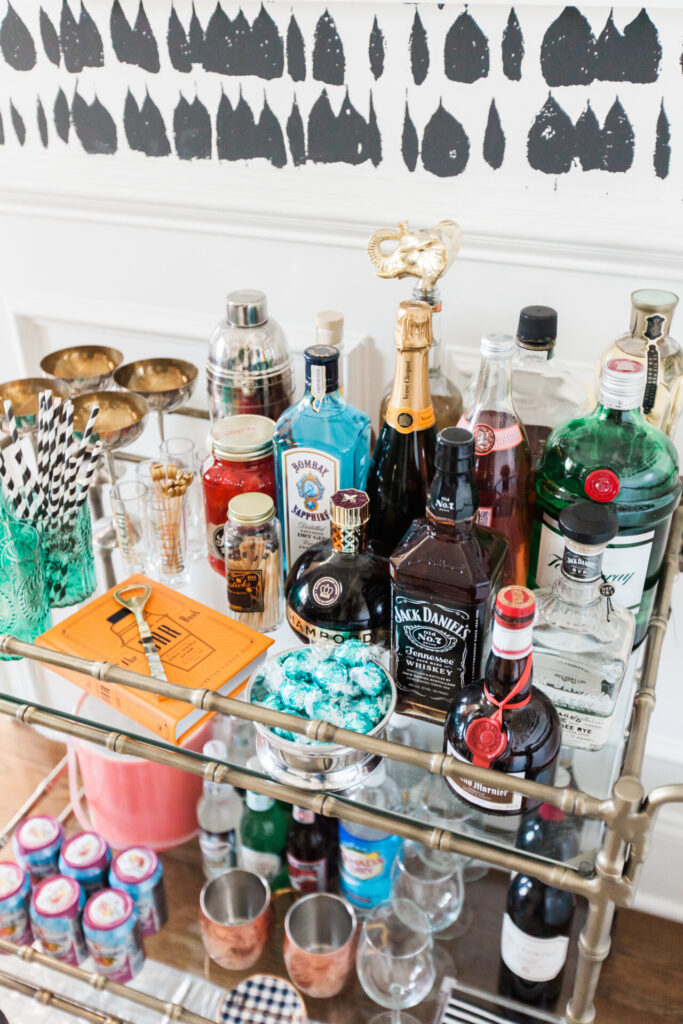 Bar Cart Essentials by popular Nashville lifestyle blog, Hello Happiness: image of a Ballard Designs Jill Bar Cart, framed Minted Moorten Cactus Study 1 print, Pottery Barn Harrison Bottle Coaster, Amazon The Essential Bar Book: An A-to-Z Guide to Spirits, Cocktails, and Wine, with 115 Recipes for the World's Great Drinks, and Schumacher QUEEN OF SPAIN wallpaper.
